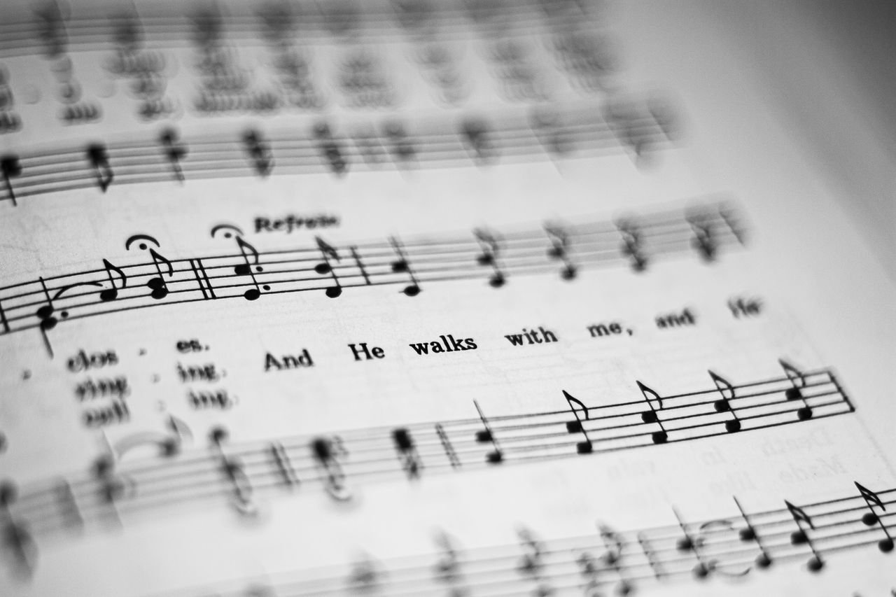 about-01 Close-up of black and white sheet music featuring musical notes and lyrics in focus.
