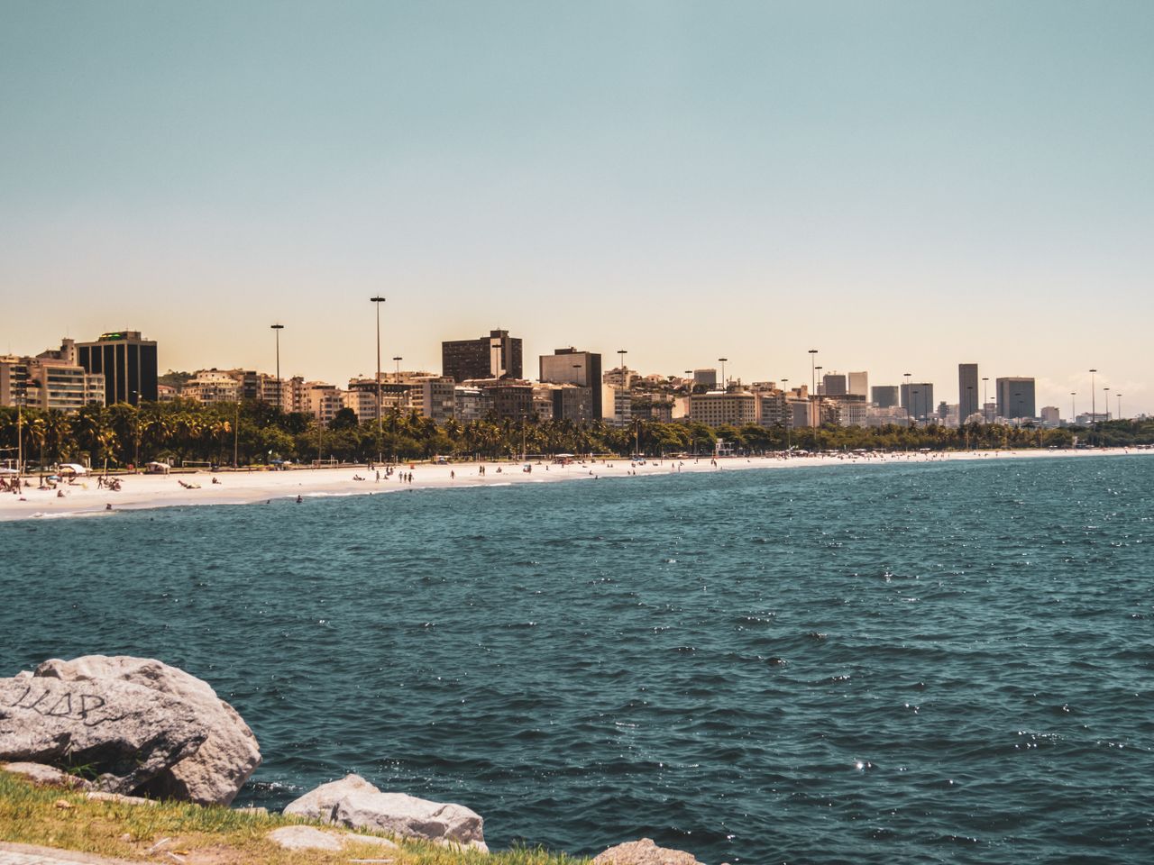 why-choose-us Beautiful beachfront in Rio de Janeiro with cityscape and ocean views.
